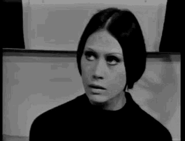 a black and white photo of a woman making a face .
