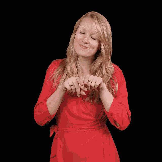 a woman in a red dress is making a funny face with her hands
