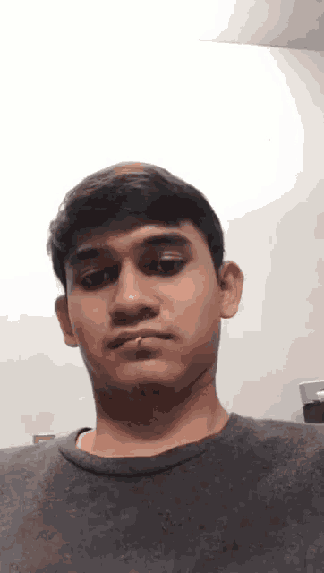 a young man with a cigarette in his mouth is looking at the camera