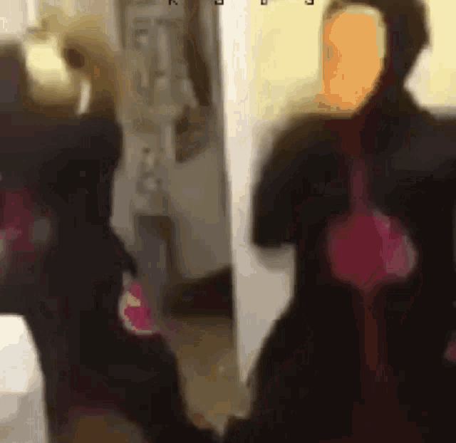 a group of people are standing in a room and one of them is wearing a mask .