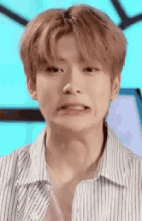 a close up of a young man making a funny face with his mouth open .