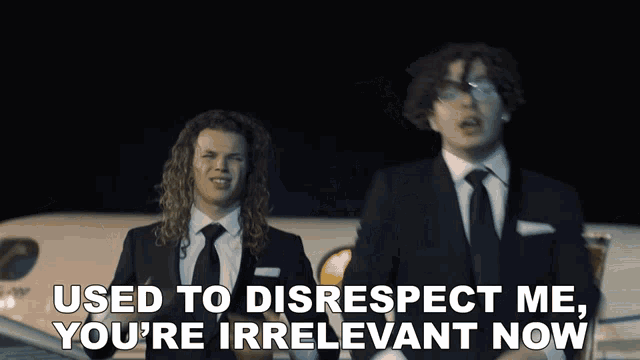 two men in suits standing next to each other with the words used to disrespect me you 're irrelevant now behind them