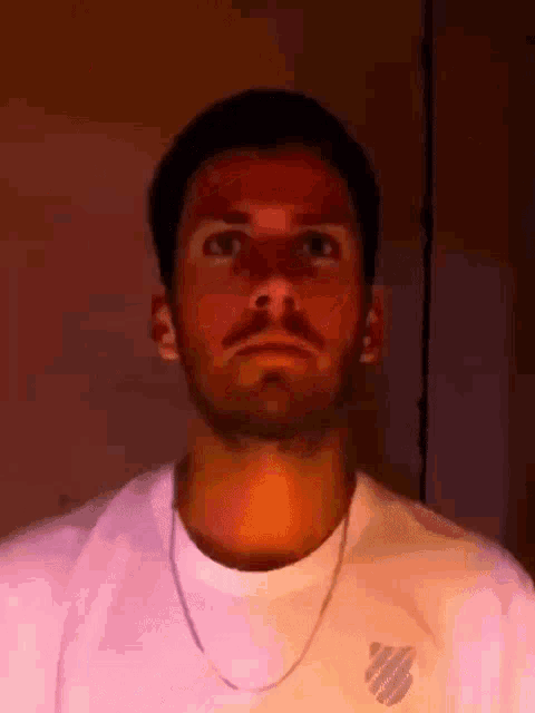 a man with a beard wearing a k swiss t-shirt