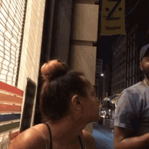 a woman kisses a man on the cheek in front of a sign that says ' zapatos '