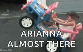 a little girl is riding in a toy car with the words arianna almost there written on it .