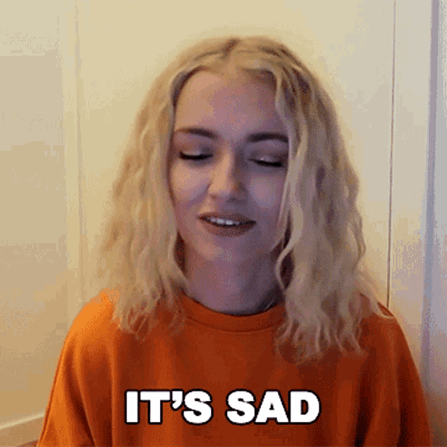 a blonde woman wearing an orange sweatshirt says it 's sad