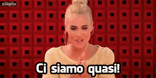 a woman is standing in front of a red wall and says ci siamo quasi !