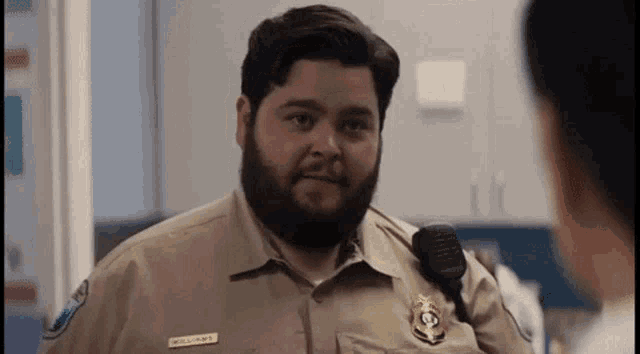 a police officer with a beard is talking to a woman .