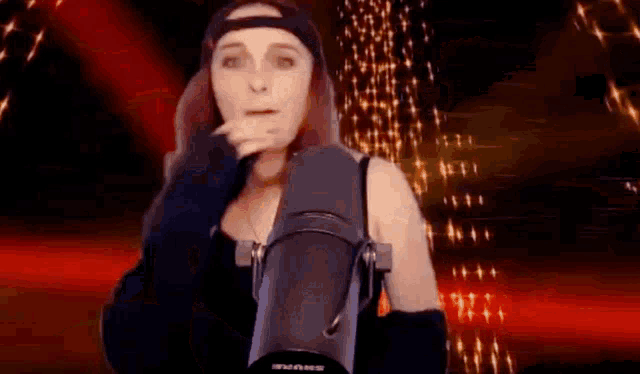 a woman is standing in front of a microphone and smoking a cigarette .
