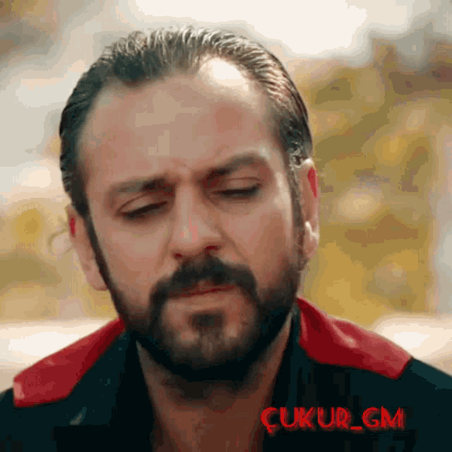 a close up of a man 's face with the words ' çukur gm ' on the bottom right