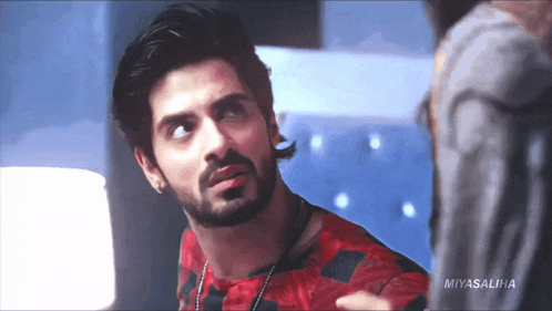 a man with a beard is wearing a red shirt that says miyasaliha