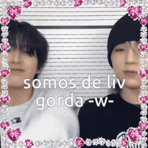 a couple of men standing next to each other in front of a wall with the words somos de liv gorda w written on it .