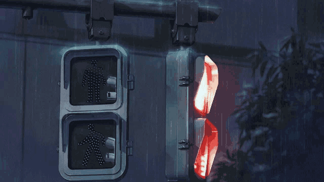 a green pedestrian crossing sign is lit up next to a red light
