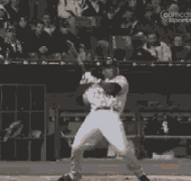 a baby is looking at a baseball player swinging a bat