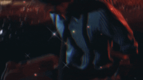 a blurry image of a person with red hair in a dark room