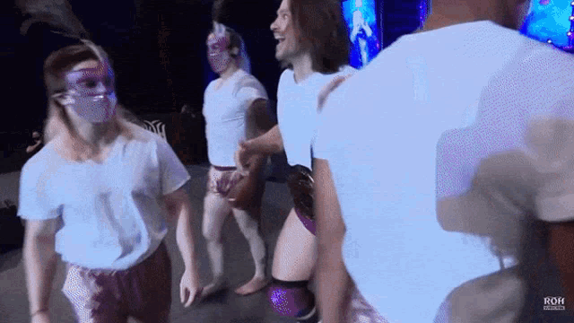 a group of people are dancing in front of a sign that says roh on it