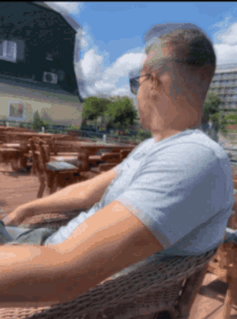 a man wearing sunglasses is sitting in a chair