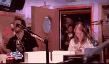 a man and a woman are talking into microphones in a radio station .
