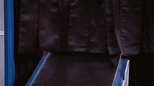 a person 's feet are on a conveyor belt with a clock in the background that says ' clock '