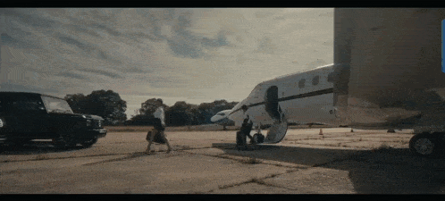 a man is walking towards a private jet on the tarmac