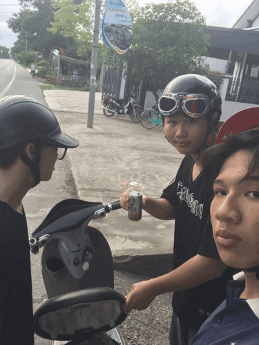 a boy wearing a black shirt that says ' eclectic ' on it is holding a can of soda