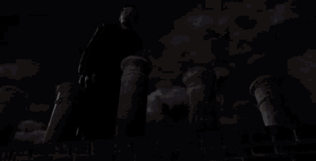 a row of chimneys are lit up at night with a full moon in the sky