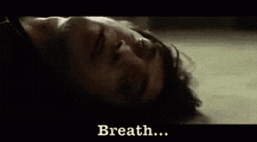a man is laying on the floor with his eyes closed and the words breath written on the bottom .