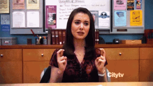 a woman is sitting at a desk in front of a citytv sign