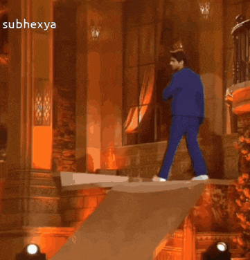 a man in a blue suit is walking across a ledge with the words subhexya below him
