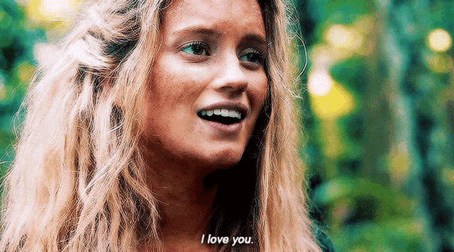a woman with blonde hair is smiling and saying i love you
