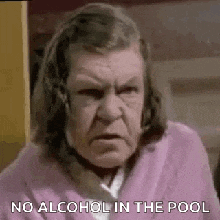 an elderly woman in a pink robe is making a funny face and says `` no alcohol in the pool '' .