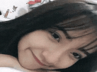 a close up of a woman laying on her stomach and smiling .
