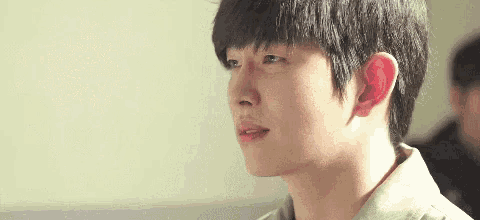 a close up of a young man 's face with a serious look on his face