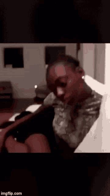 a man in a military uniform is sitting on a couch with his eyes closed .