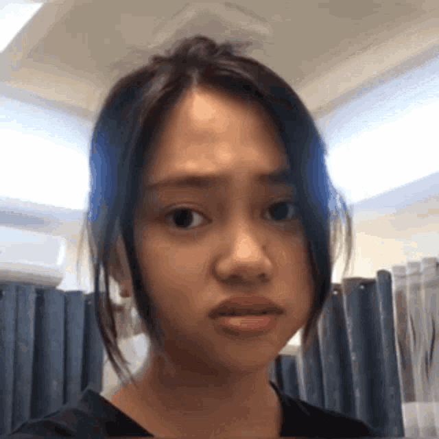 a young woman is making a funny face with her mouth open .