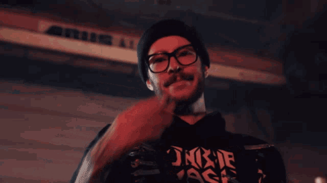 a man smoking a cigarette wearing a black shirt that says junk de ass
