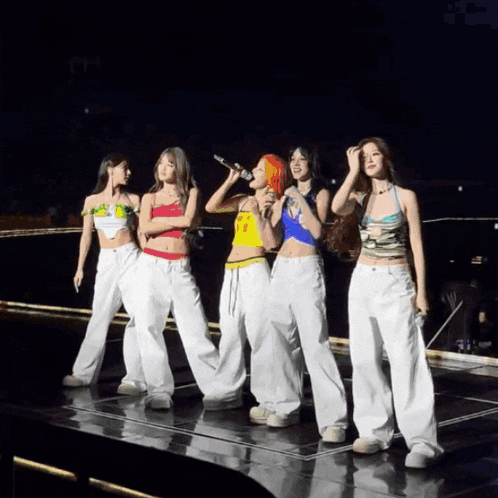 a group of women singing into microphones on stage