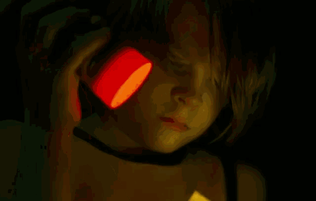 a person is cutting a piece of paper with scissors in a dark room