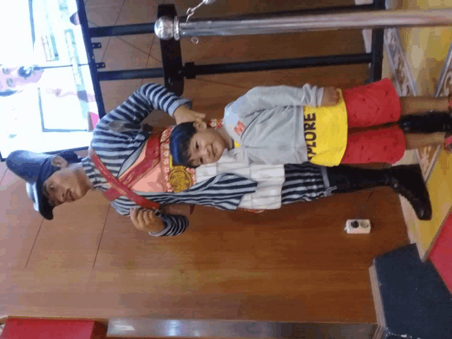 a boy wearing a yellow shirt that says explore stands next to a man