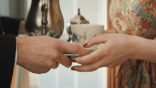a man and a woman are holding a cup of coffee