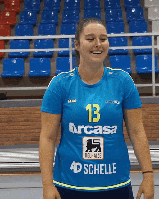 a girl wearing a blue shirt with the number 13 on the front
