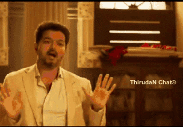 a man in a suit is making a funny face with his hands in the air