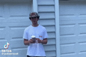 a shirtless man is standing in front of a basketball hoop holding a water balloon