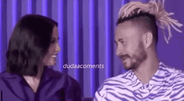 a man and a woman are looking at each other and smiling .