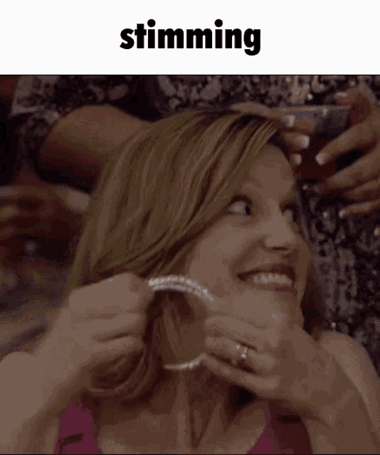 a woman is smiling while putting on a pair of hoop earrings