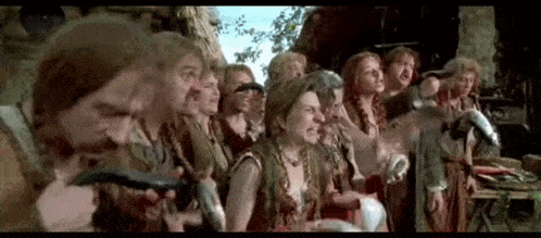 a group of people are standing next to each other in a row holding horns .