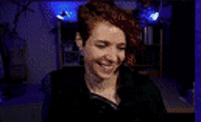 a woman with red hair is smiling and looking at the camera .