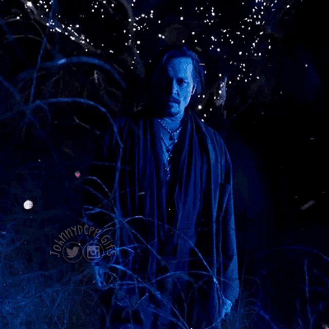a man with a red circle on his forehead is surrounded by blue lights and a logo for johnny depp