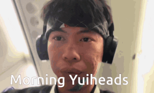 a man wearing headphones and a headband with the words morning yuiheads above him