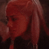 a close up of a woman 's face in a dark room with red hair .